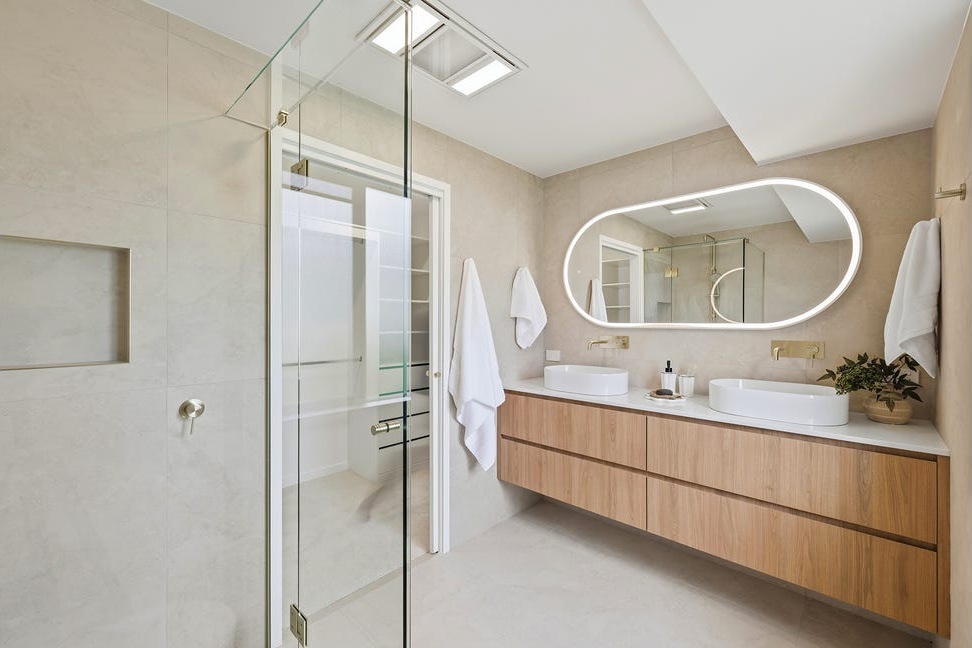 Completed double-basin vanity with illuminated mirror and glass shower