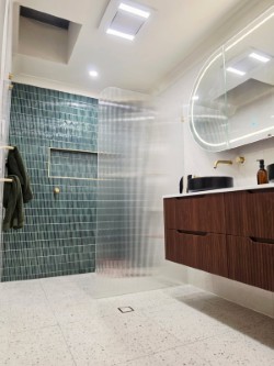 Completed bathroom renovation with feature tiles and timber vanity